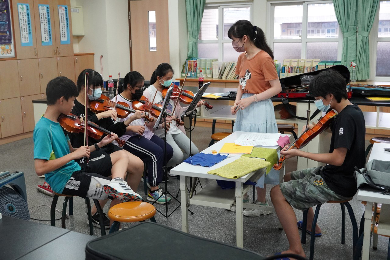 志 工 老 師 教 導 孩 子 學 琴 